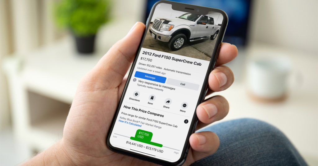 A picture of a smart phone with a used Ford F-150 Facebook Marketplace listing on screen. 