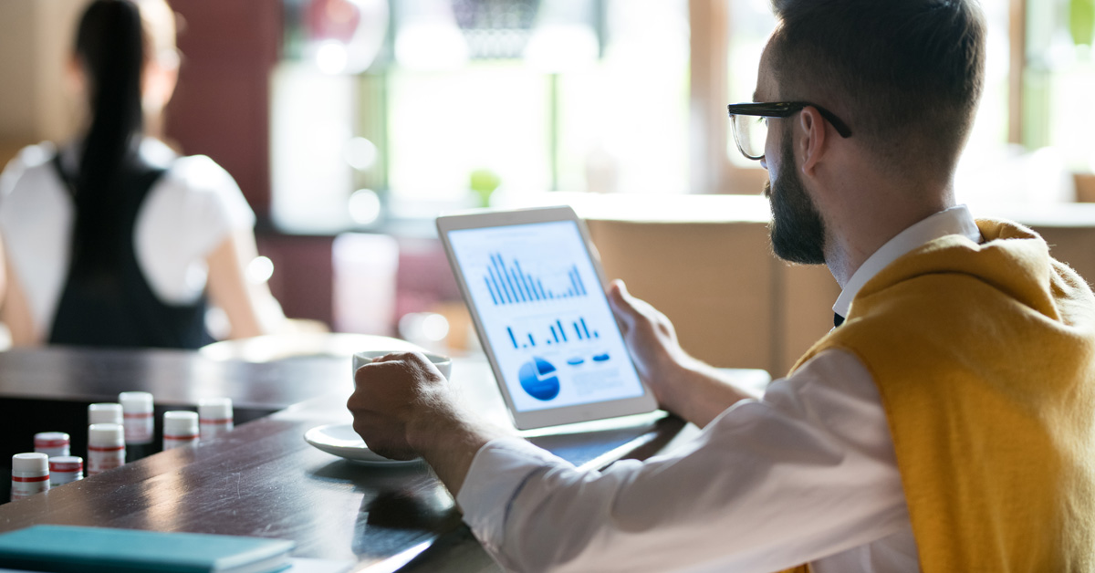 Man Reviewing Reports on Tablet