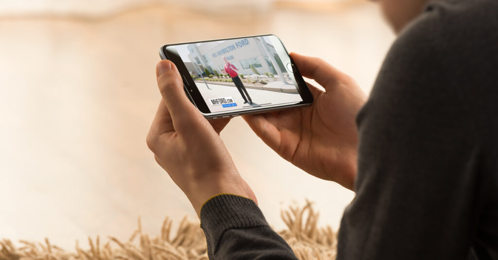 200722.1---Mel-Hambelton-Ford-YouTube-Case-Study-Image---Dealer-Teamwork---1200x628 Person watching a youtube video on their phone