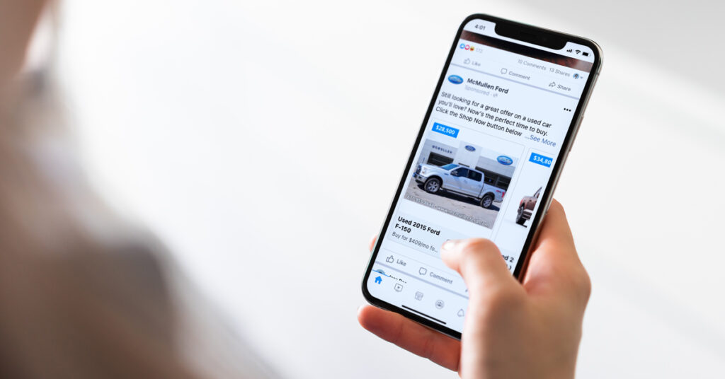 210309.1---McMullen-Ford-Case-Study---Dealer-Teamwork---Header-Image---1200x628 Person looking at Facebook ad for vehicles for sale on their cell phone